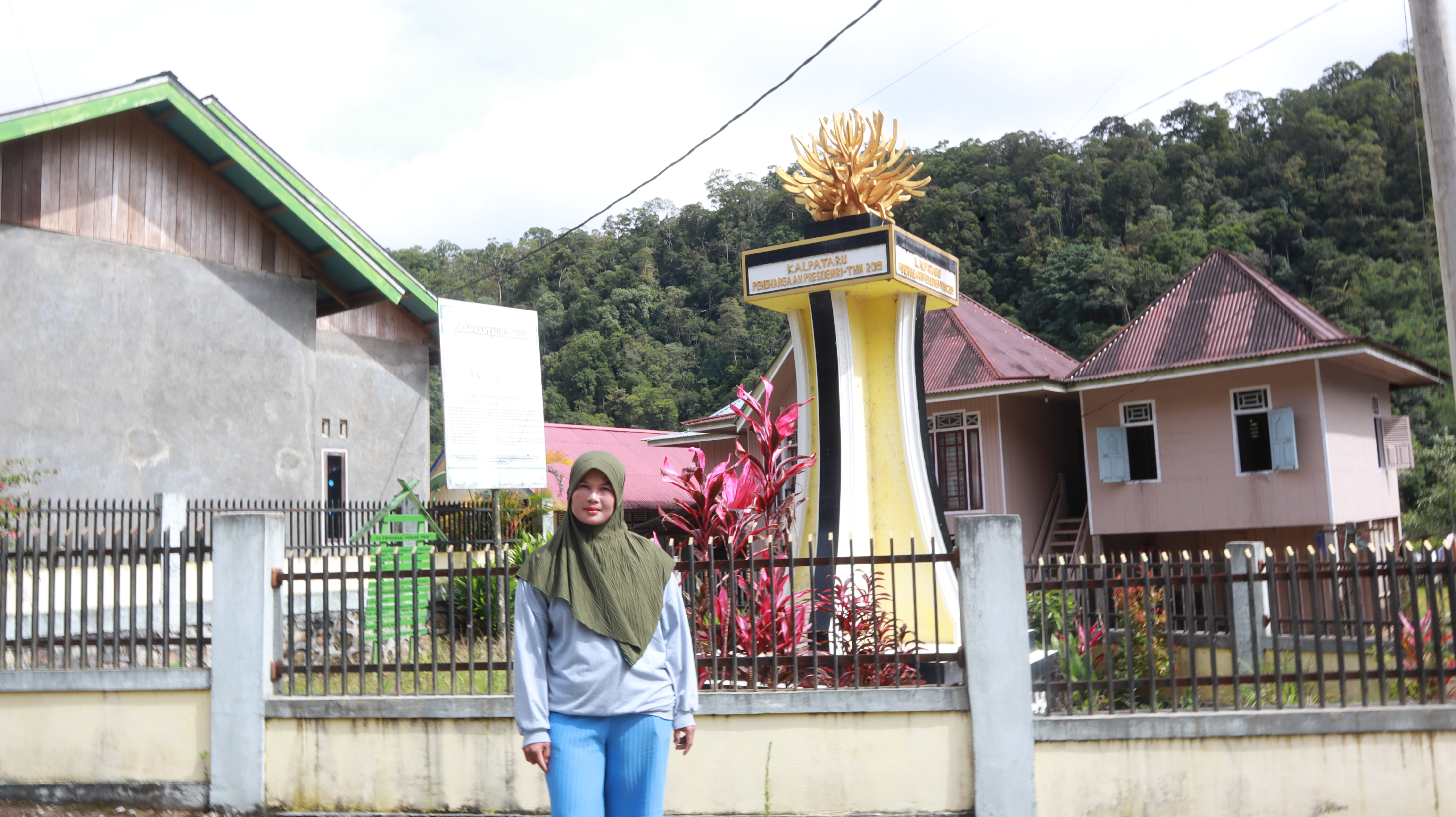 Ledia, anggota KPHA Depati Karo Jayo, berdiri di monument Kalpataru yang menjadi simbol pengharagaan atas ketangguhan dalam menjaga hutan adat. (Foto: M Sobar Alfahri)